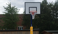 Outdoor steel playground in ground basketball goal posts.